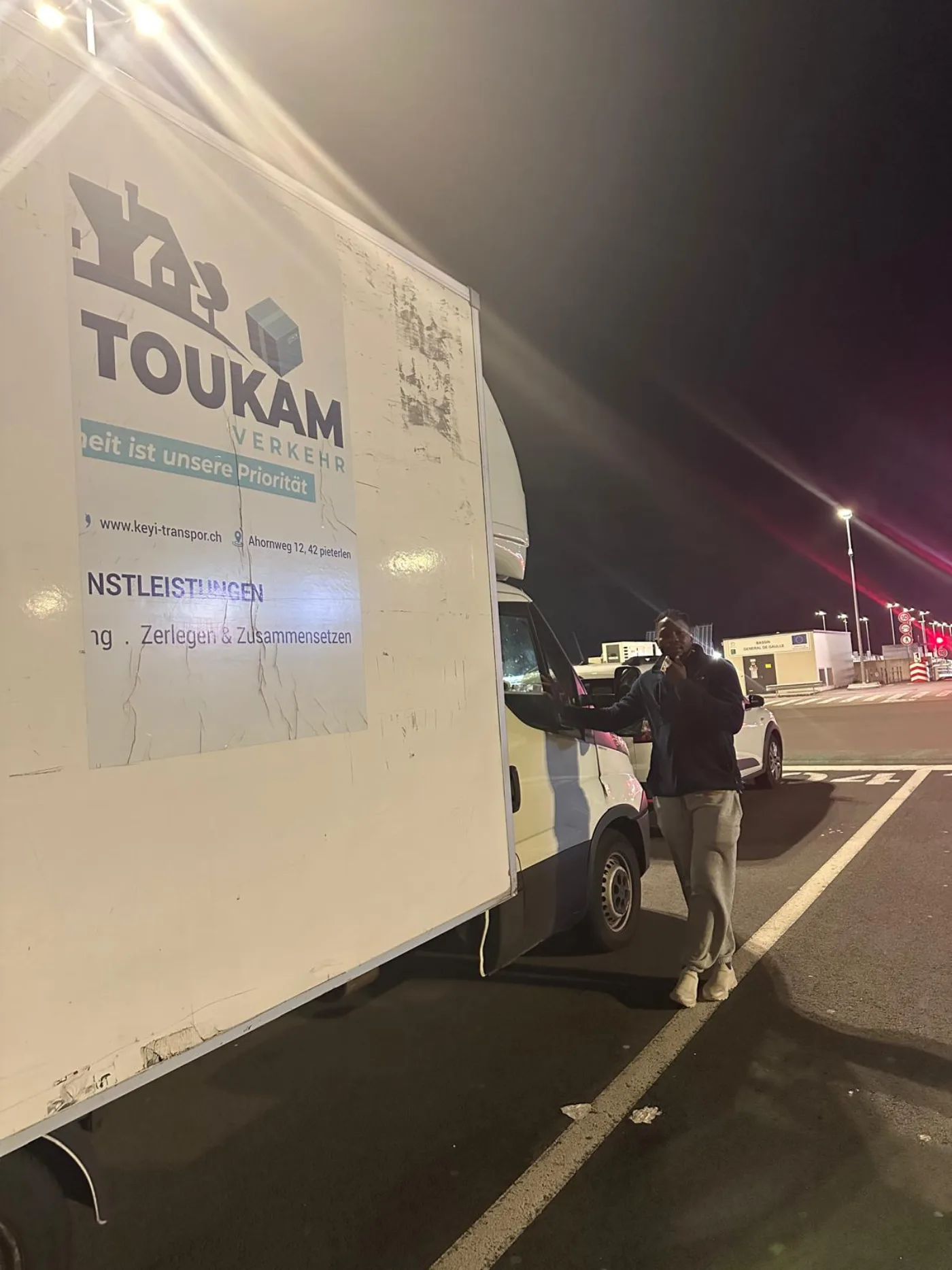 Patron Keyi Transport devant son camion la nuit